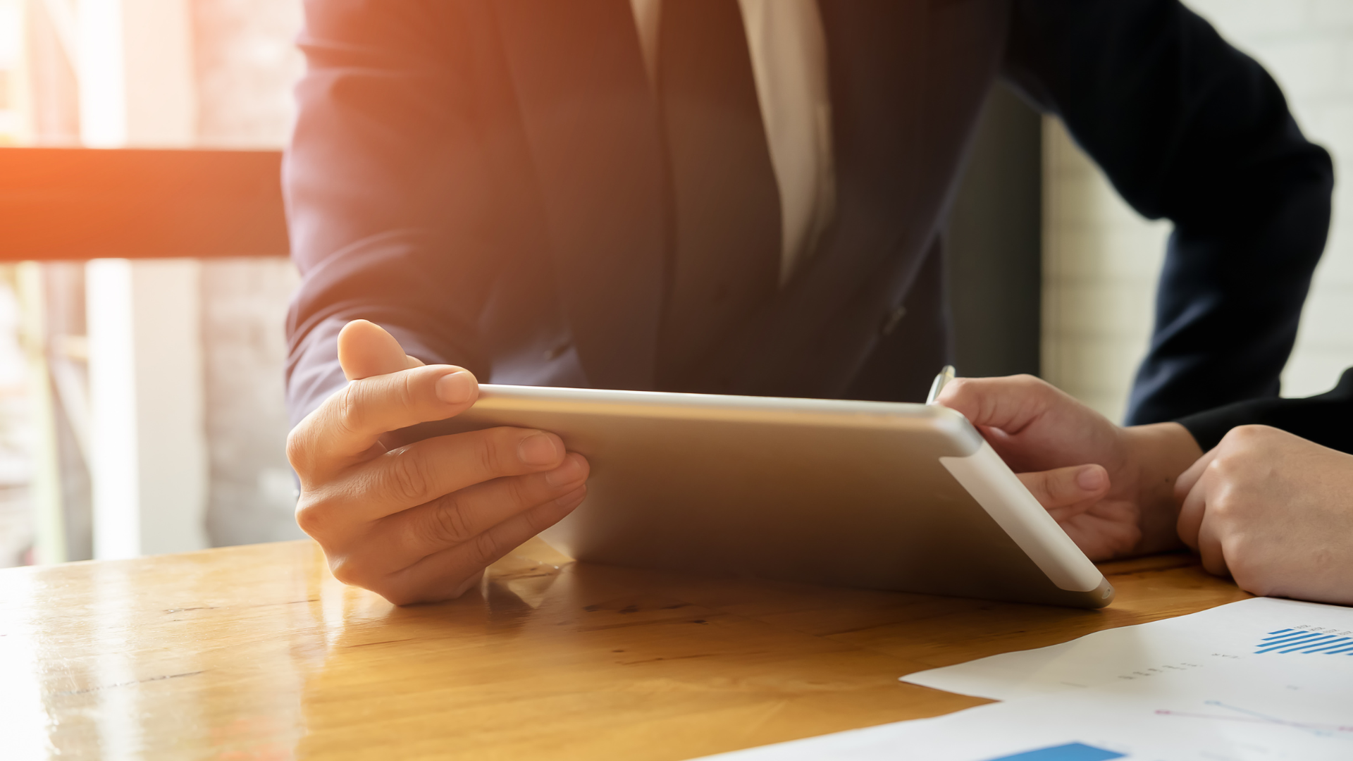 Manos de dos personas revisando información en una tablet